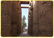 Ancient stone columns with hieroglyphics in a temple corridor in Egypt.
