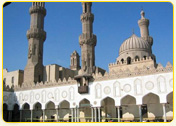 Architectural view of the Al-Azhar Mosque in Cairo, showcasing its minarets and domes against a clear sky.