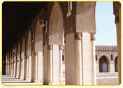 Architectural columns with intricate designs in a historic building featuring arched openings.