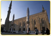 Historic mosque with tall minarets and intricate architectural details in Cairo, Egypt.